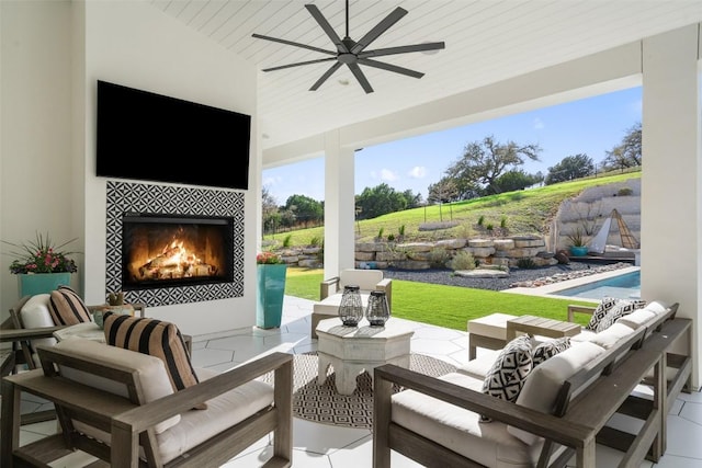 view of patio / terrace featuring an outdoor living space with a fireplace and a ceiling fan