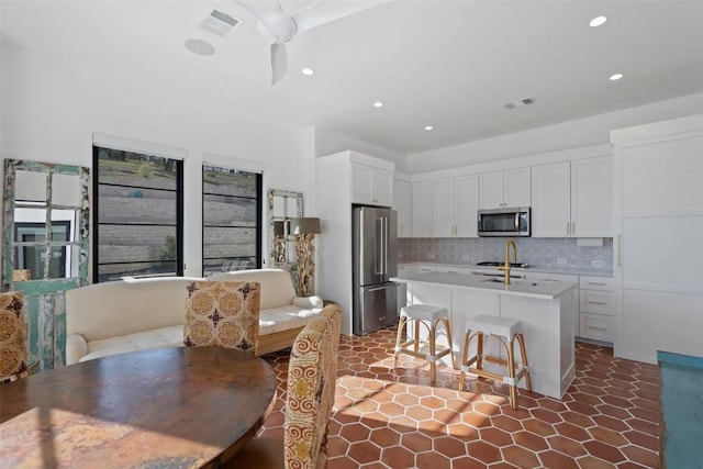 kitchen featuring recessed lighting, stainless steel appliances, visible vents, decorative backsplash, and white cabinetry