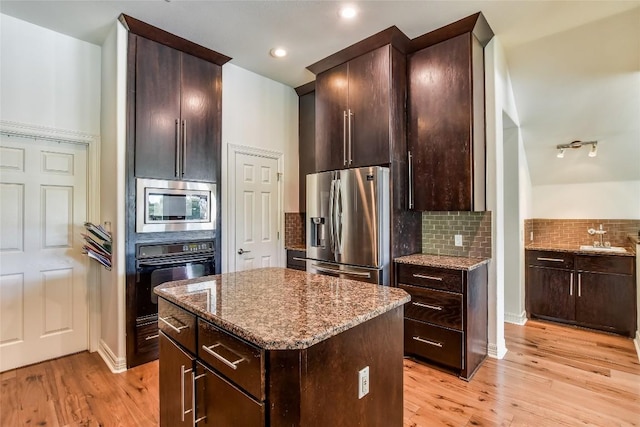 5802 Gentle Breeze Ter, Austin, TX 78731 - kitchen featuring stainless steel appliances, stone counters, backsplash, light wood-style floors, and recessed lighting
