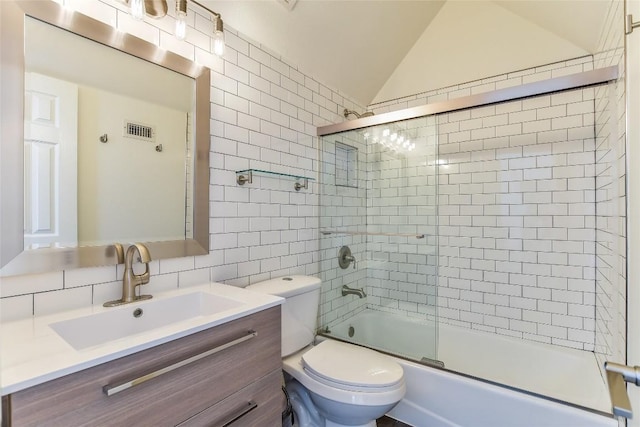 5802 Gentle Breeze Ter, Austin, TX 78731 - full bath with tile walls, vanity, bath / shower combo with glass door, vaulted ceiling, and backsplash