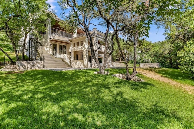 5802 Gentle Breeze Ter, Austin, TX 78731 - rear view of house with a balcony, stairs, a yard, and stucco siding