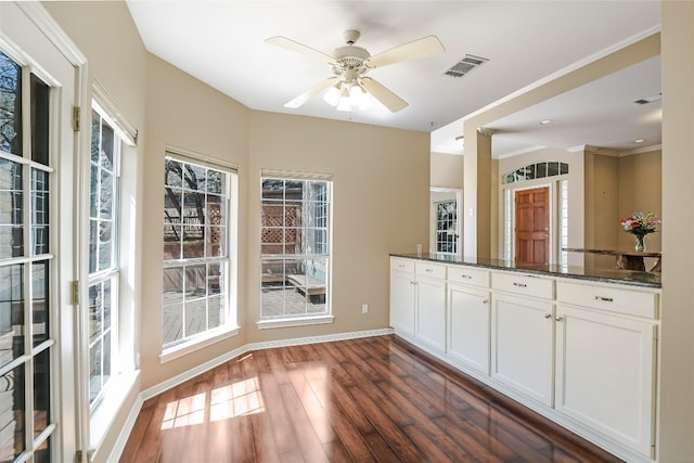 6407 Johanne Ct, Austin, TX 78750 - kitchen featuring white cabinetry, dark wood-style floors, dark stone counters, ceiling fan, and ornamental molding