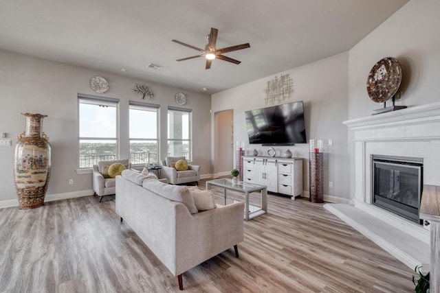 1304 Positano Pass, Leander, TX 78641 - living area with ceiling fan, light wood finished floors, baseboards, and a glass covered fireplace