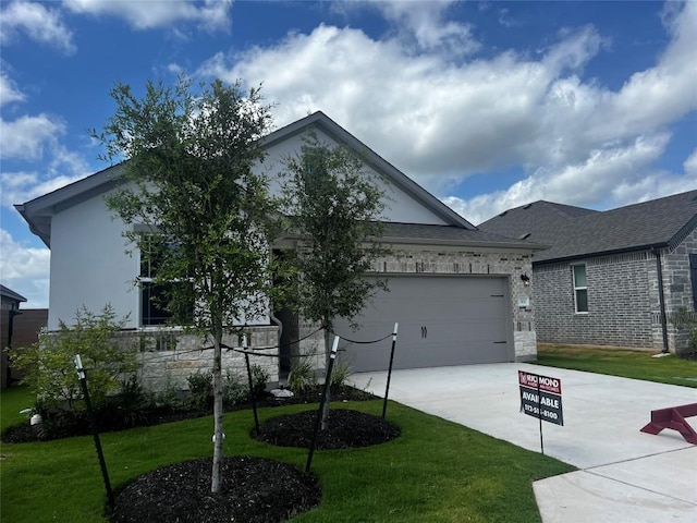 513 Raleigh Dr, Georgetown, TX 78633 - view of front of house with concrete driveway, a front lawn, a garage, and stone siding