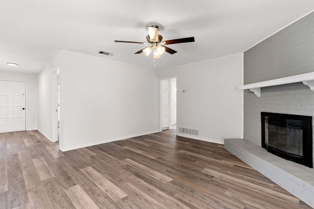 unfurnished living room with a ceiling fan, wood finished floors, and visible vents