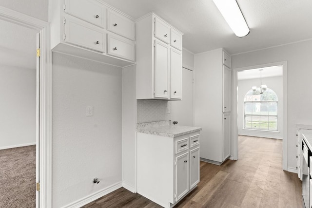 kitchen featuring white cabinetry, baseboards, light countertops, and wood finished floors