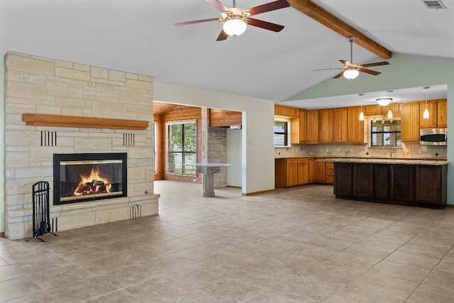 209 Senisa Dr, Buchanan Dam, TX 78609 - kitchen with light countertops, plenty of natural light, a fireplace, ceiling fan, and stainless steel microwave