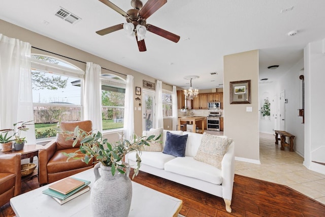 105 Wimberley St, Hutto, TX 78634 - living room featuring a chandelier, ceiling fan, light wood finished floors, and baseboards