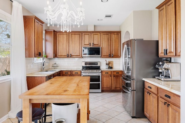 105 Wimberley St, Hutto, TX 78634 - kitchen featuring stainless steel appliances, a sink, and brown cabinetry