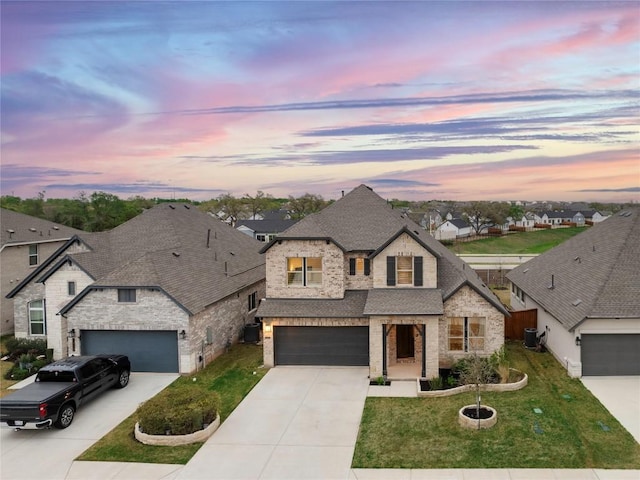 1017 Dog Iron St, Georgetown, TX 78633 - french country style house featuring concrete driveway, stone siding, a front yard, and roof with shingles