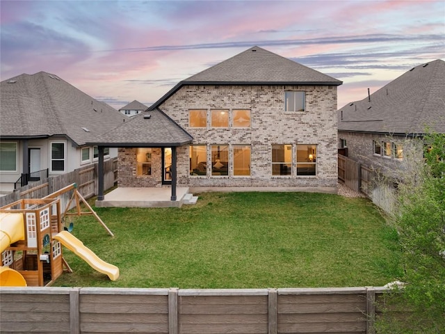1017 Dog Iron St, Georgetown, TX 78633 - back of property at dusk with a fenced backyard, a patio area, roof with shingles, brick siding, and a playground