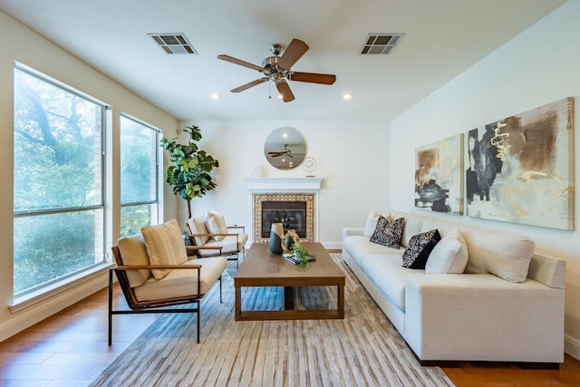 7724 Yaupon Dr, Austin, TX 78759 - living area with plenty of natural light, a glass covered fireplace, a ceiling fan, wood finished floors, and recessed lighting