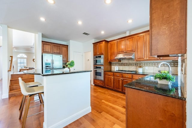 7724 Yaupon Dr, Austin, TX 78759 - kitchen featuring stainless steel fridge, under cabinet range hood, a sink, light wood finished floors, and backsplash