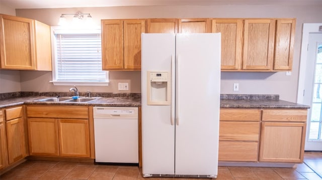 2312 Devonshire Dr, Austin, TX 78723 - kitchen featuring white appliances, dark countertops, light brown cabinetry, and light tile patterned floors
