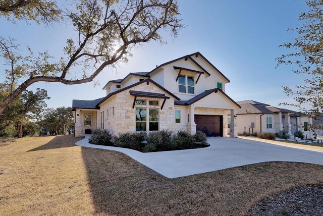 6109 Destination Way, Lago Vista, TX 78645 - view of front of home with stone siding, driveway, a garage, a front lawn, and stucco siding