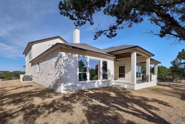6109 Destination Way, Lago Vista, TX 78645 - back of house with a chimney, stone siding, covered porch, and a ceiling fan