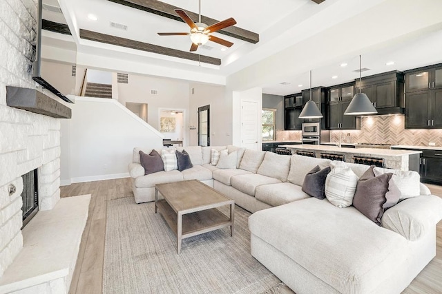 6109 Destination Way, Lago Vista, TX 78645 - living room featuring ceiling fan, a stone fireplace, light wood finished floors, stairs, and recessed lighting