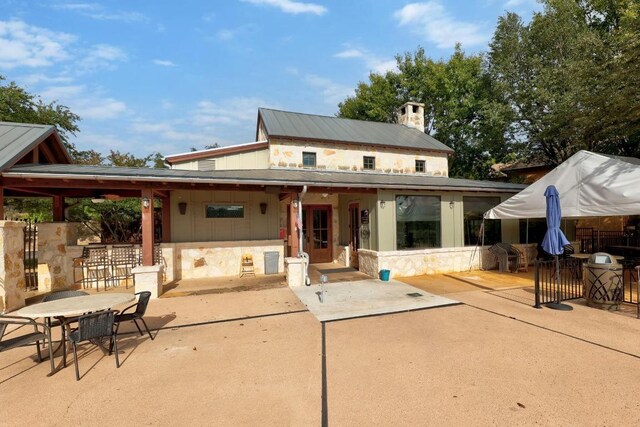 6109 Destination Way, Lago Vista, TX 78645 - rear view of house featuring a patio area, a metal roof, and stone siding