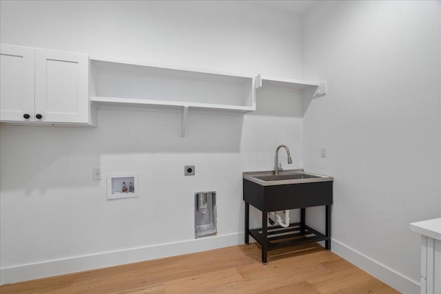 13400 Paisano Trl, Austin, TX 78737 - washroom with hookup for an electric dryer, washer hookup, light wood-style floors, cabinet space, and baseboards