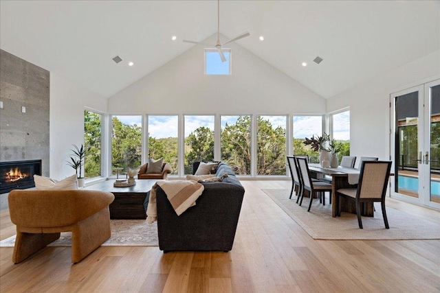 13400 Paisano Trl, Austin, TX 78737 - living area with high vaulted ceiling, a tile fireplace, light wood finished floors, a ceiling fan, and french doors