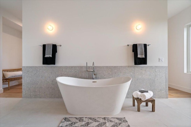 13400 Paisano Trl, Austin, TX 78737 - bathroom featuring tile walls, a freestanding tub, tile patterned floors, and a wainscoted wall
