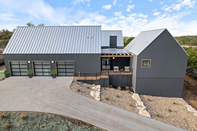 13400 Paisano Trl, Austin, TX 78737 - view of front of property featuring a standing seam roof, driveway, metal roof, a garage, and stucco siding