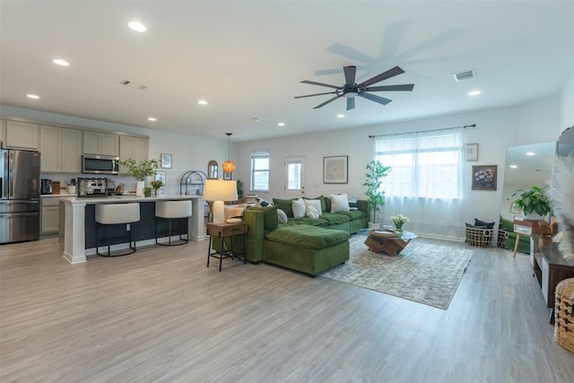 12305 Zenyatta Dr, Buda, TX 78610 - living area featuring light wood-style floors, plenty of natural light, and visible vents
