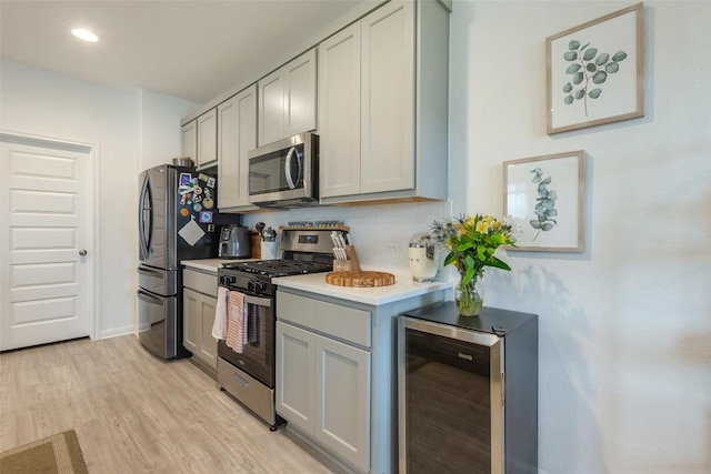 12305 Zenyatta Dr, Buda, TX 78610 - kitchen featuring light countertops, gray cabinetry, wine cooler, stainless steel appliances, and light wood-style flooring