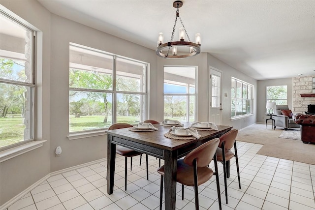 591 Young Ranch Rd, Georgetown, TX 78633 - dining area with a chandelier, baseboards, light tile patterned floors, and a stone fireplace