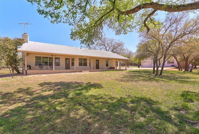 591 Young Ranch Rd, Georgetown, TX 78633 - rear view of house with a yard, a chimney, metal roof, and a garage