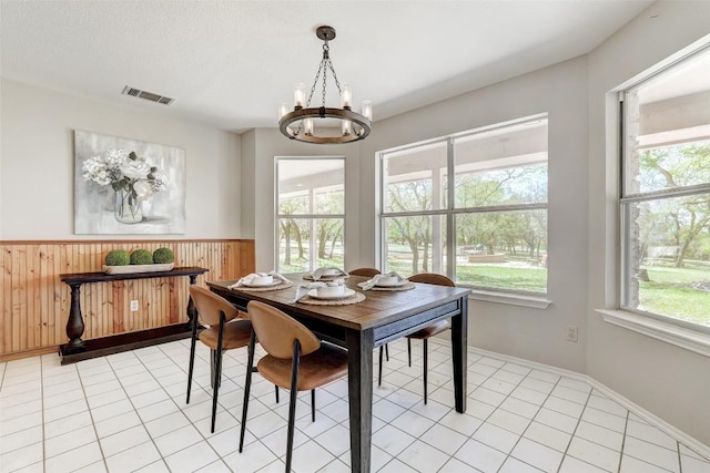 591 Young Ranch Rd, Georgetown, TX 78633 - dining space with a chandelier, wooden walls, and a wainscoted wall