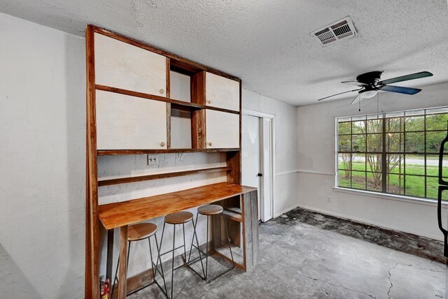2511 Bitter Creek Dr, Austin, TX 78744 - kitchen featuring unfinished concrete flooring, a textured ceiling, a ceiling fan, open shelves, and white cabinets