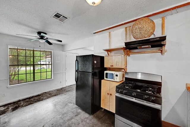 2511 Bitter Creek Dr, Austin, TX 78744 - kitchen with stainless steel range with gas stovetop, freestanding refrigerator, white microwave, a textured ceiling, and a ceiling fan