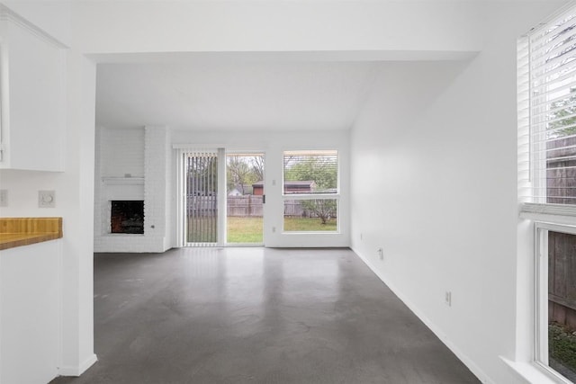 12503 Brandywine Ct, Austin, TX 78727 - unfurnished living room with finished concrete floors, a fireplace, and baseboards