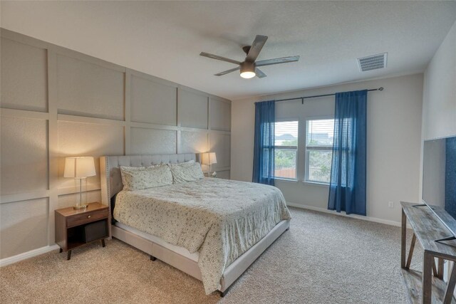 312 Heatherwood Ter, Marble Falls, TX 78654 - bedroom with a decorative wall, visible vents, a ceiling fan, and light carpet