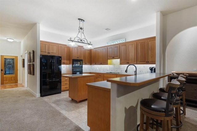 510 N Horseshoe Bay Blvd, Horseshoe Bay, TX 78657 - kitchen with black appliances, a center island, a breakfast bar area, a peninsula, and decorative light fixtures