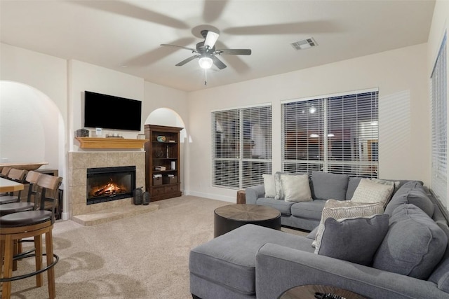 510 N Horseshoe Bay Blvd, Horseshoe Bay, TX 78657 - living room with light colored carpet, ceiling fan, a tile fireplace, baseboards, and arched walkways