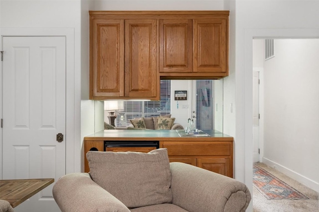 510 N Horseshoe Bay Blvd, Horseshoe Bay, TX 78657 - kitchen featuring a sink, brown cabinetry, baseboards, and carpet