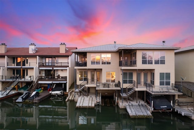 510 N Horseshoe Bay Blvd, Horseshoe Bay, TX 78657 - rear view of property with stucco siding, boat lift, stairway, a standing seam roof, and a chimney