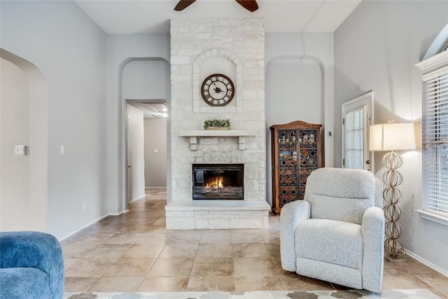14516 Wharton Park Trl, Austin, TX 78717 - living room featuring a ceiling fan, arched walkways, a fireplace, and plenty of natural light