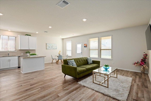 living area featuring visible vents, recessed lighting, light wood finished floors, and baseboards