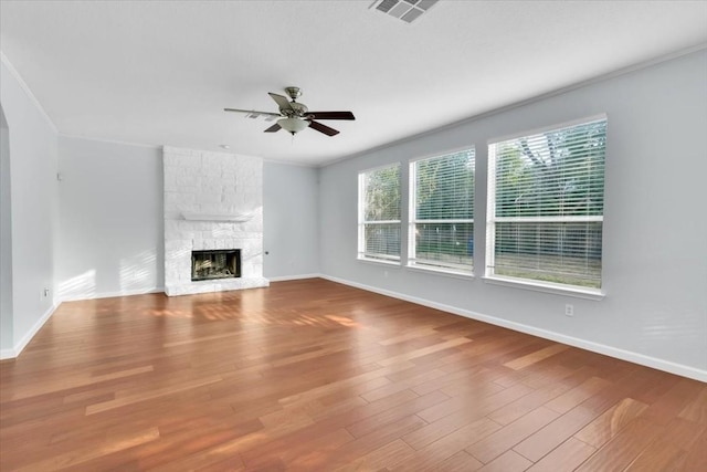 16101 Mcdows Hole Ln, Austin, TX 78717 - unfurnished living room with ceiling fan, baseboards, a fireplace, wood finished floors, and crown molding