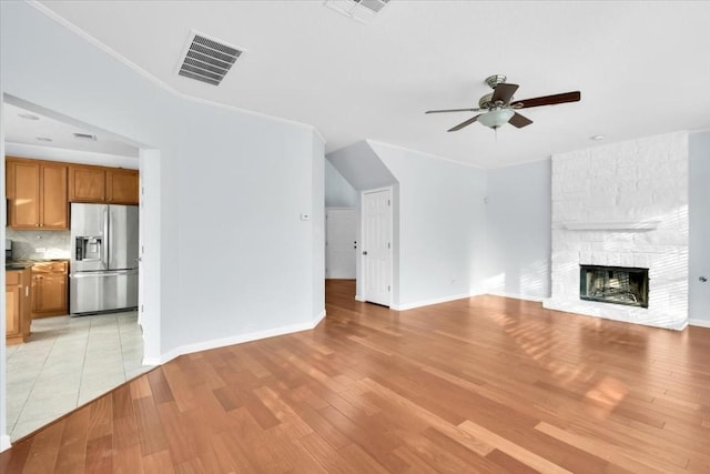 16101 Mcdows Hole Ln, Austin, TX 78717 - unfurnished living room featuring a ceiling fan, a fireplace, light wood-type flooring, and baseboards