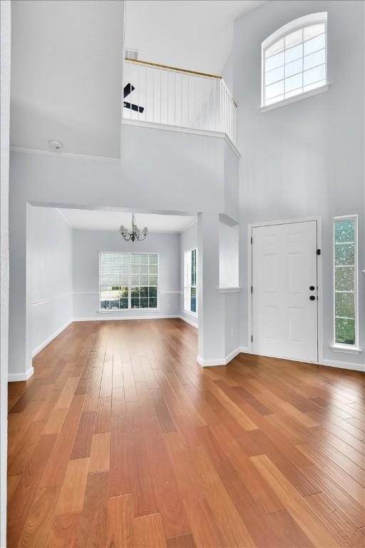 16101 Mcdows Hole Ln, Austin, TX 78717 - entryway with a chandelier, light wood-style flooring, a high ceiling, and baseboards
