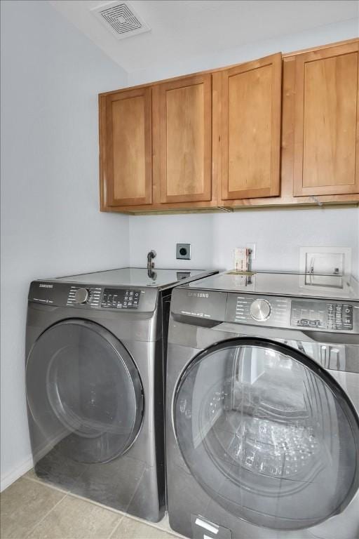 16101 Mcdows Hole Ln, Austin, TX 78717 - laundry area featuring cabinet space, separate washer and dryer, and tile patterned floors