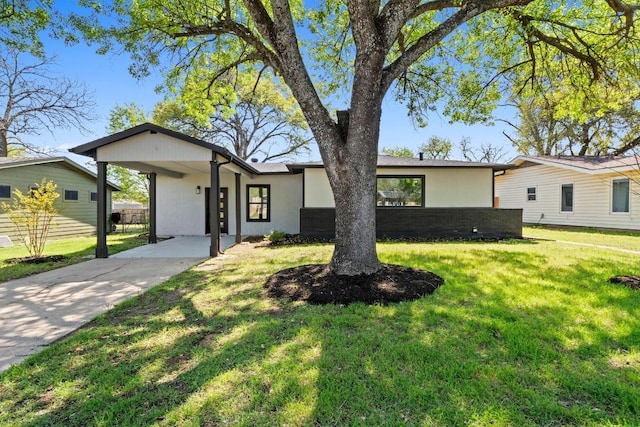 view of front of property with a front yard and concrete driveway