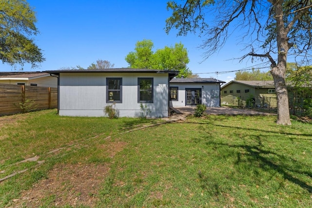 view of front of property with a front yard, fence, and a patio
