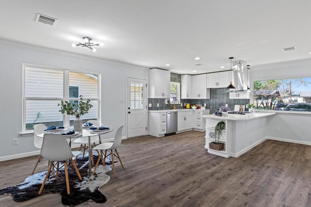kitchen with white cabinets, visible vents, island exhaust hood, tasteful backsplash, and stainless steel dishwasher