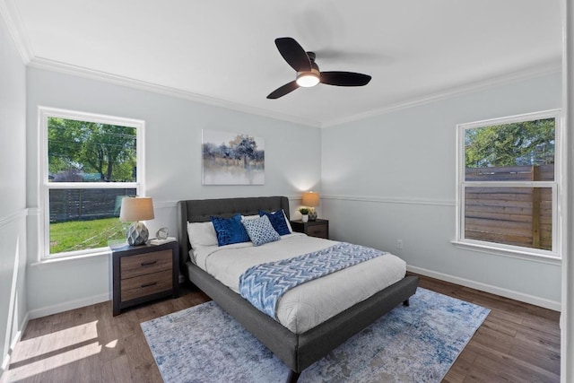 bedroom with crown molding, baseboards, and wood finished floors