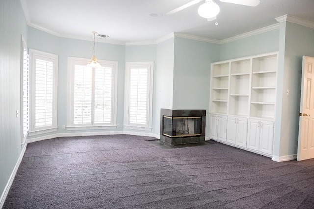unfurnished living room featuring a wealth of natural light, visible vents, dark colored carpet, and ceiling fan